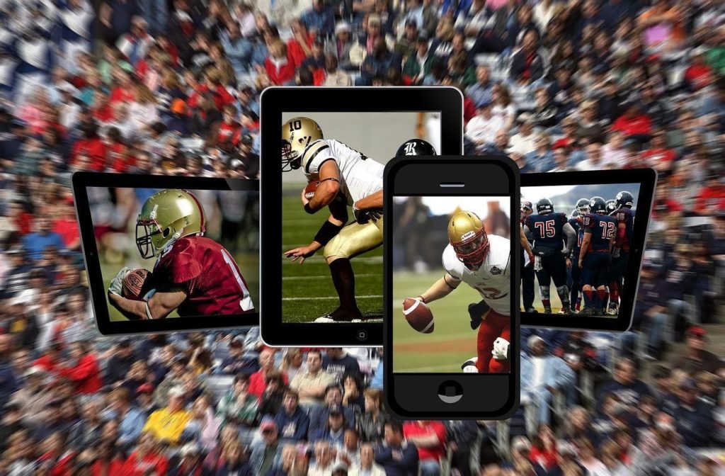 different mobile devices showing football players and matches with spectators blurred in the background